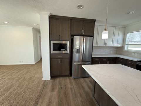 Open kitchen with stainless refrigerator, built-in microwave and island